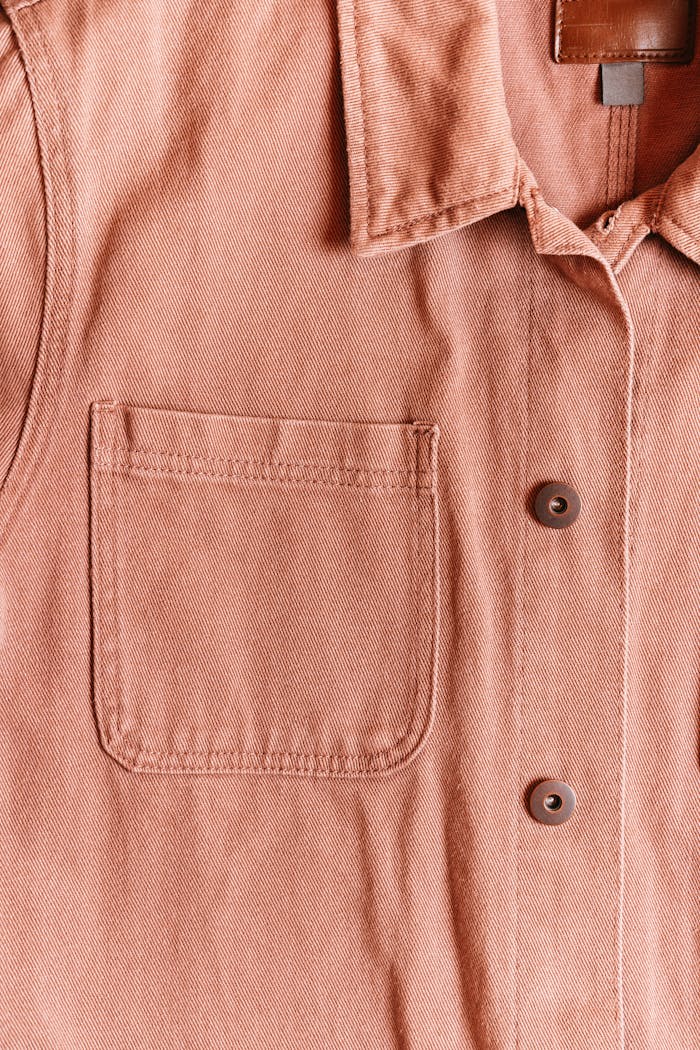 hero-img Detailed texture and design of a cotton button-up shirt with a pocket.